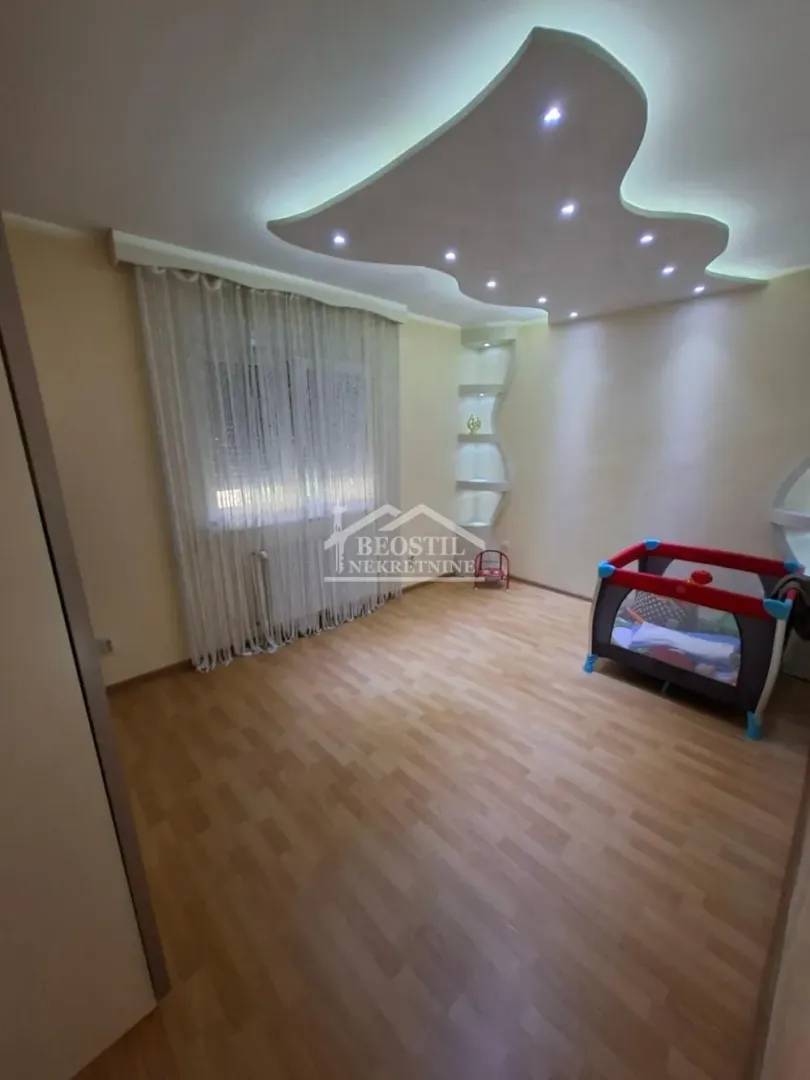 Dečja soba sa laminatom i spuštenim plafonom sa rasvetom.