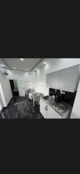 Small kitchen with a sink, electric hob, and upper cabinets. - image 6