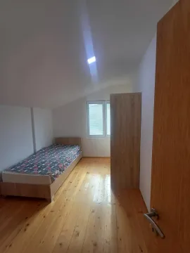 Manja spavaća soba sa krevetom, drvenim podom i ormarom. - image 15