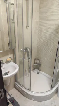Bathroom with a shower cabin and a washbasin. - image 10