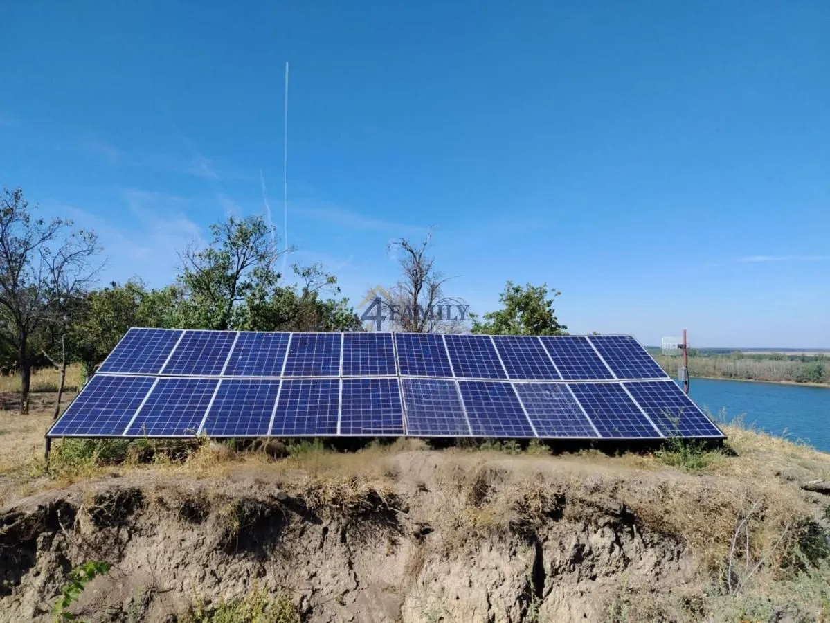Solarni paneli postavljeni na otvorenom prostoru pored reke.