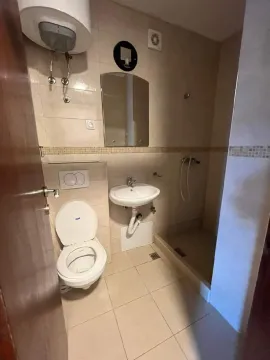 Small bathroom with a shower cabin, washbasin, and toilet. - image 5