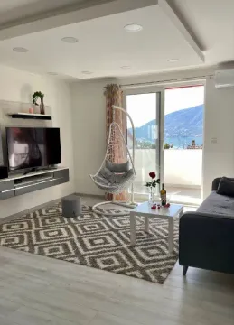 Dnevna soba sa garniturom, TV-om i izlazom na terasu sa pogledom na more. - image 7