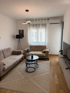 Living room with sofas, coffee tables, and a TV. - image 2