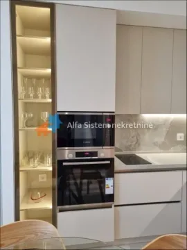 View of a modern kitchen with a built-in oven, microwave, and illuminated glass cabinet. - image 6