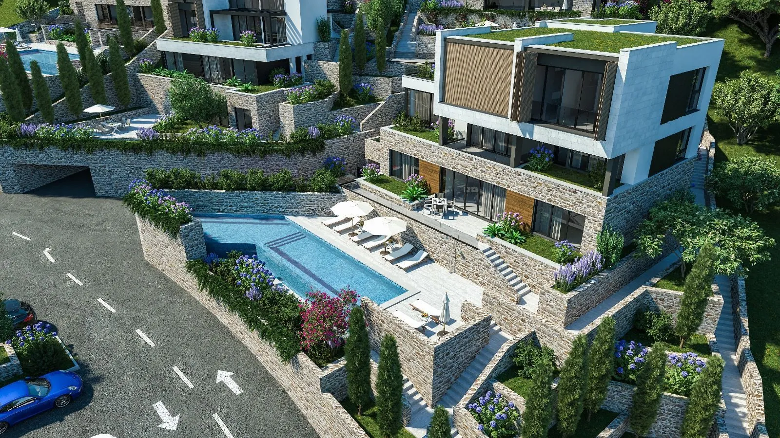 Pogled iz vazduha na kompleks modernih vila sa bazenom i uređenim terasama.