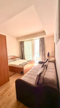 Furnished bedroom with a double bed and a sofa. - image 7