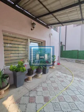 Popločano dvorište ispred kuće sa saksijama cveća. - image 3