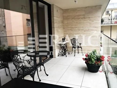 Furnished terrace with seating furniture and stone wall cladding.