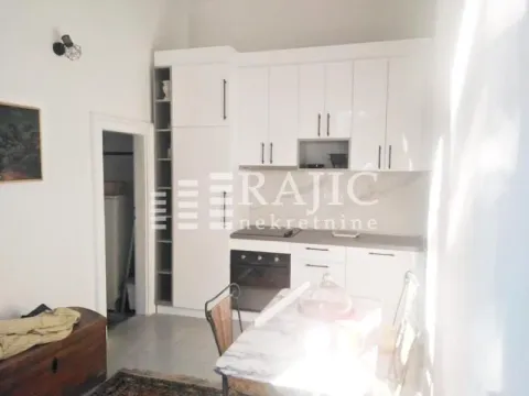 White kitchen with a dining table and chairs. - image 2