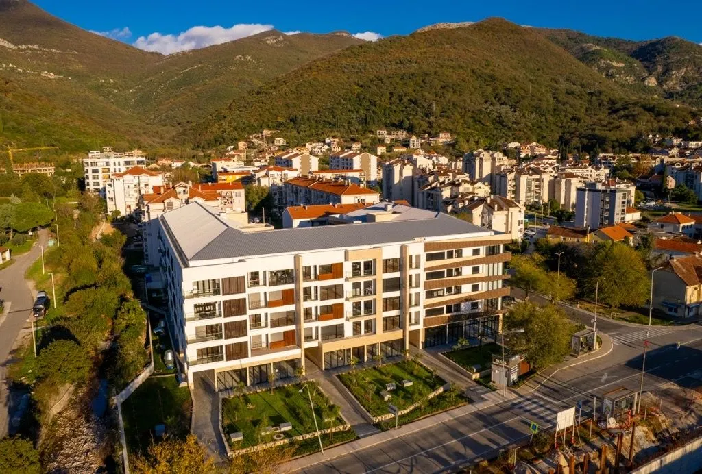 Pogled iz vazduha na novu stambenu zgradu sa uređenim dvorištem i okruženjem.