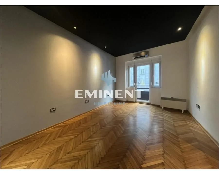 Empty room with parquet flooring and dark ceiling.