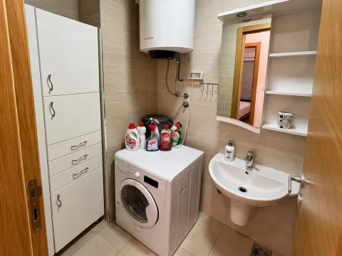 Manje kupatilo sa umivaonikom, veš mašinom, bojlerom i ugrađenim ormarićem. - image 9