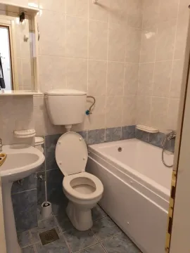 Bathroom with a bathtub, sink, and toilet. - image 5