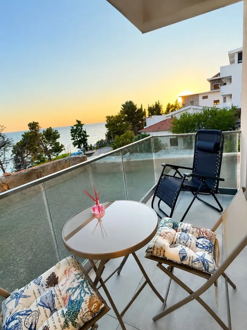 Furnished terrace with a table, chairs, and a sea view.