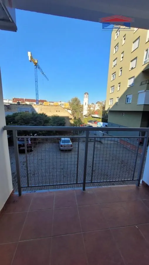 Pogled sa popločane terase na susednu zgradu i okolinu.