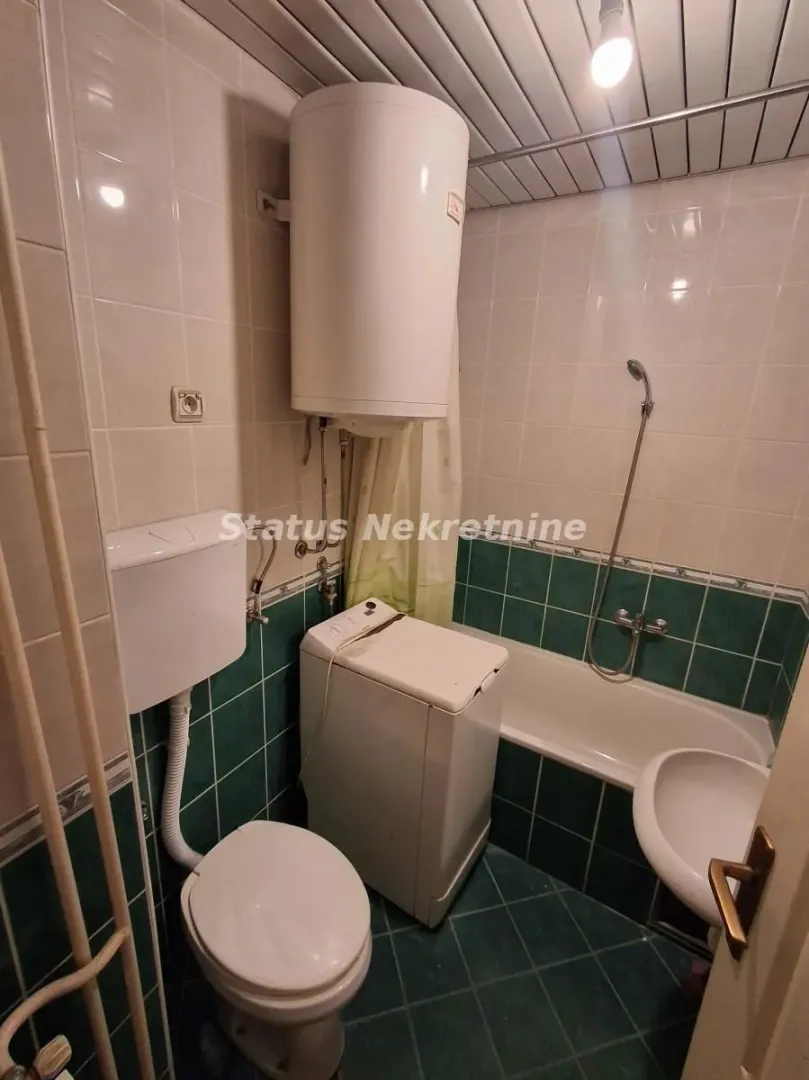 Kupatilo opremljeno kadom, wc šoljom, umivaonikom i veš mašinom.