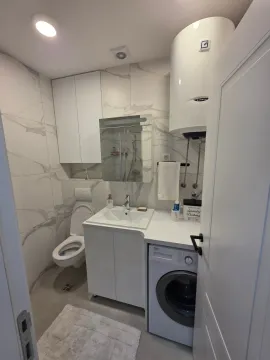 Moderno opremljeno kupatilo sa umivaonikom, wc šoljom, tuš kabinom i mašinom za veš. - image 5