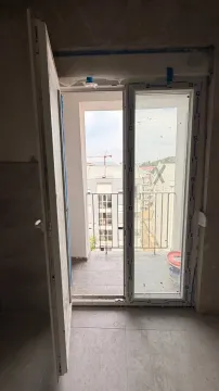 Pogled na terasu i okolne zgrade kroz otvorena balkonska vrata. - image 4