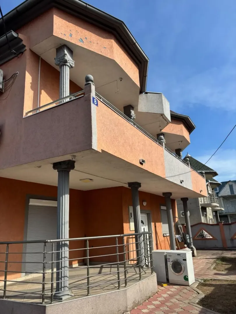 Exterior view of the house with a balcony and columns.