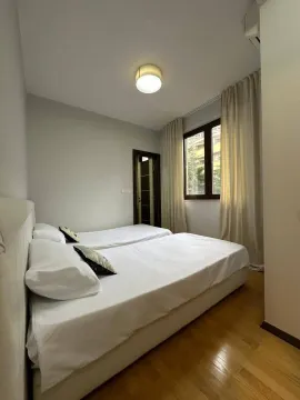 Svjetla spavaća soba sa dva kreveta i drvenim podom. - image 8
