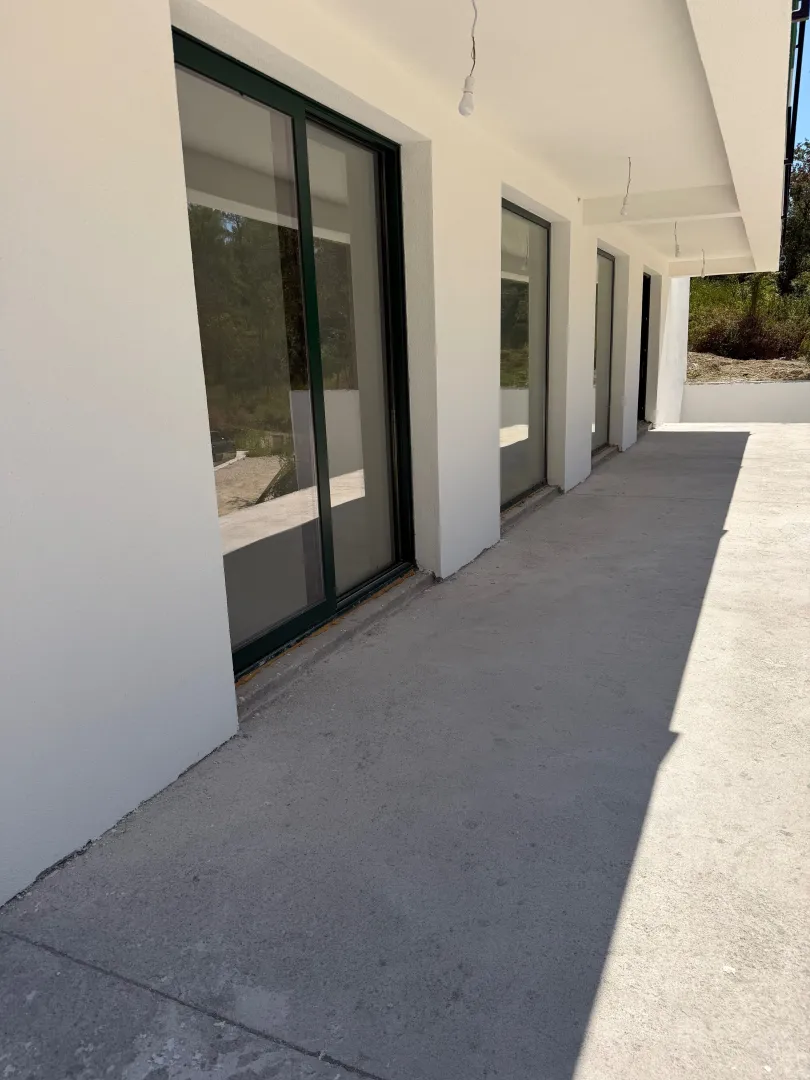 View of the covered terrace and facade of a new building.