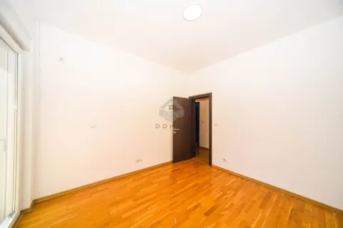 Empty room with white walls, wooden parquet flooring, and a doorway. - image 9