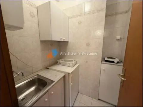 Small kitchen with a sink, refrigerator, and cabinetry. - image 9