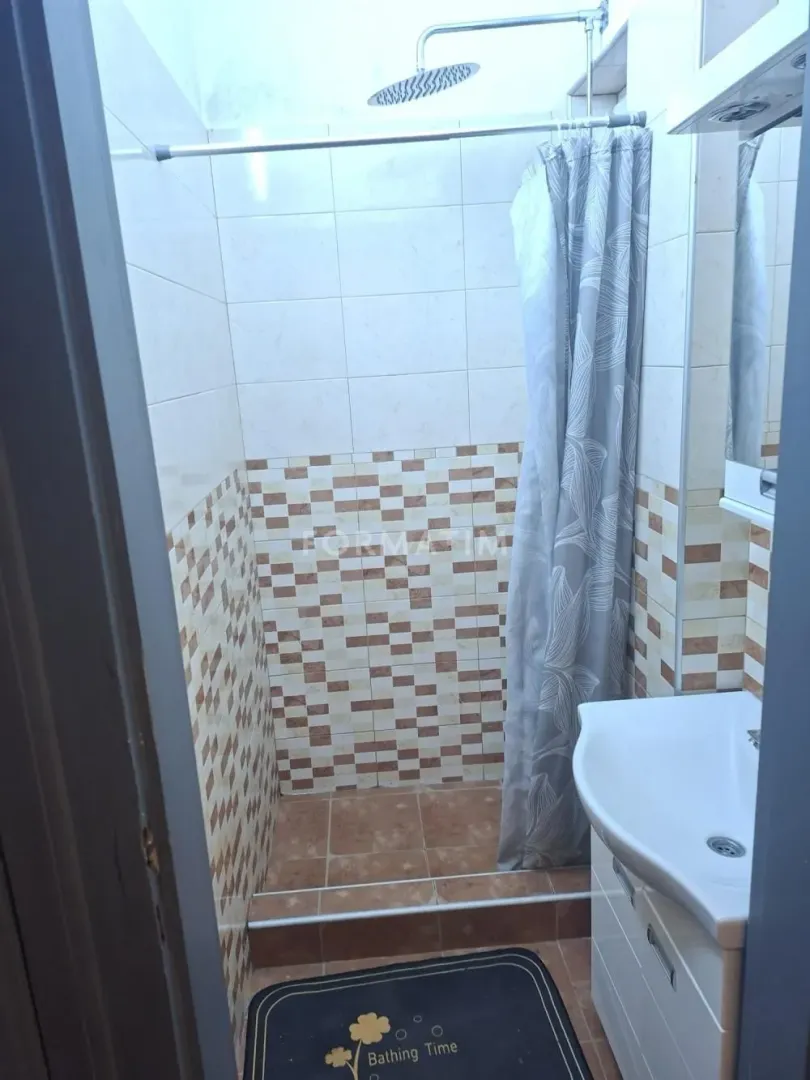 Smaller bathroom with a shower cabin and a sink.