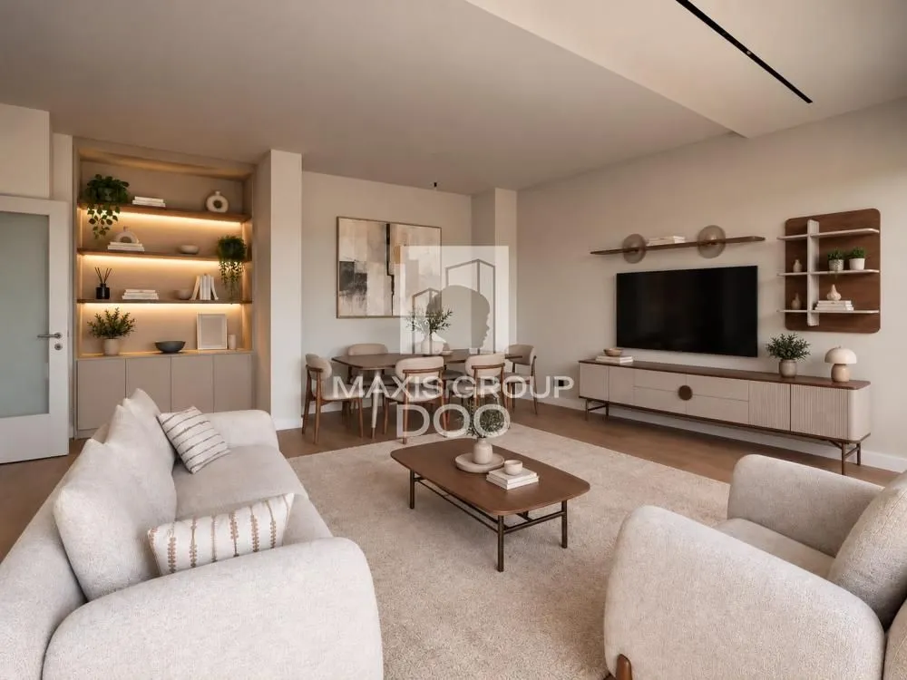 Modern living room furnished with seating, a TV, and a dining area in the background.