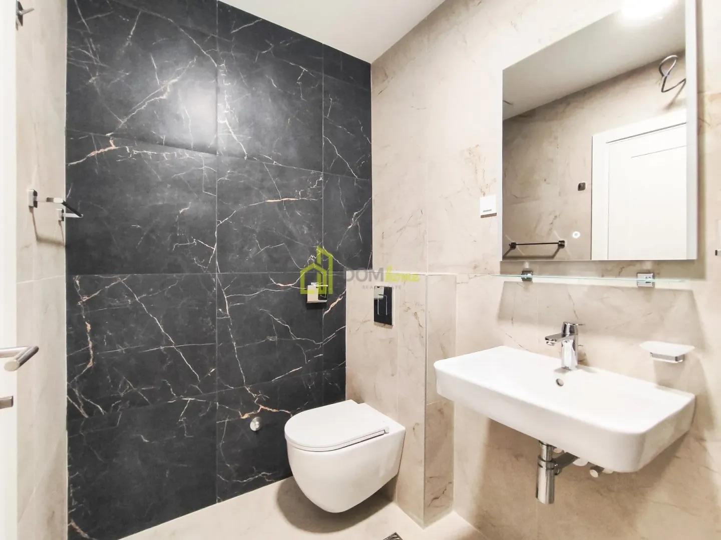 Modern bathroom equipped with a washbasin, toilet, and mirror.
