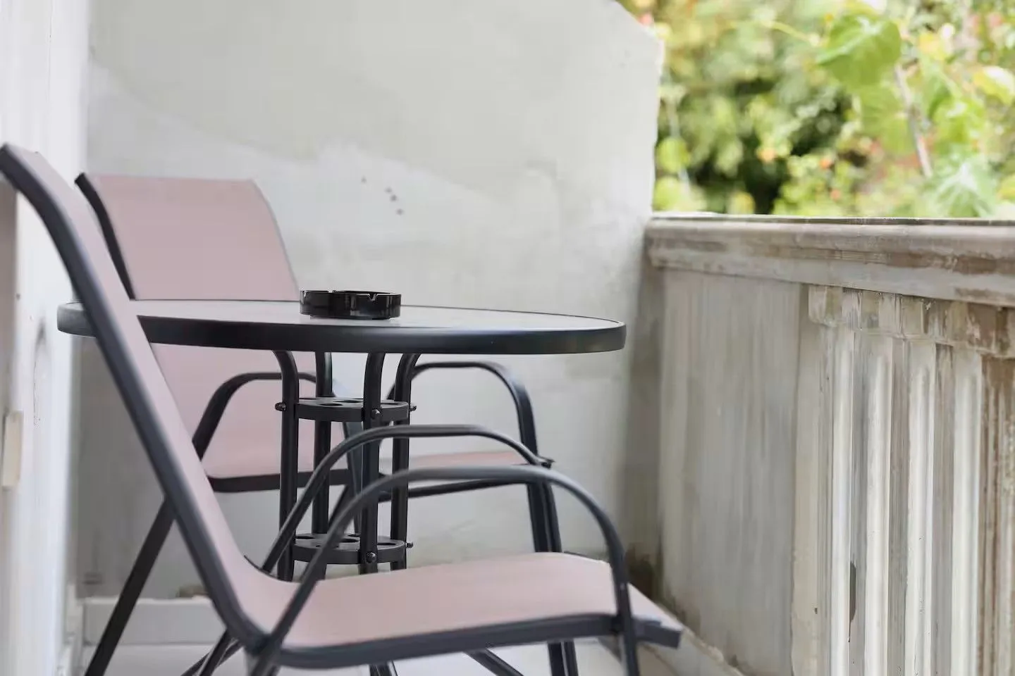 Manji namješteni balkon sa stolom i dvije stolice.