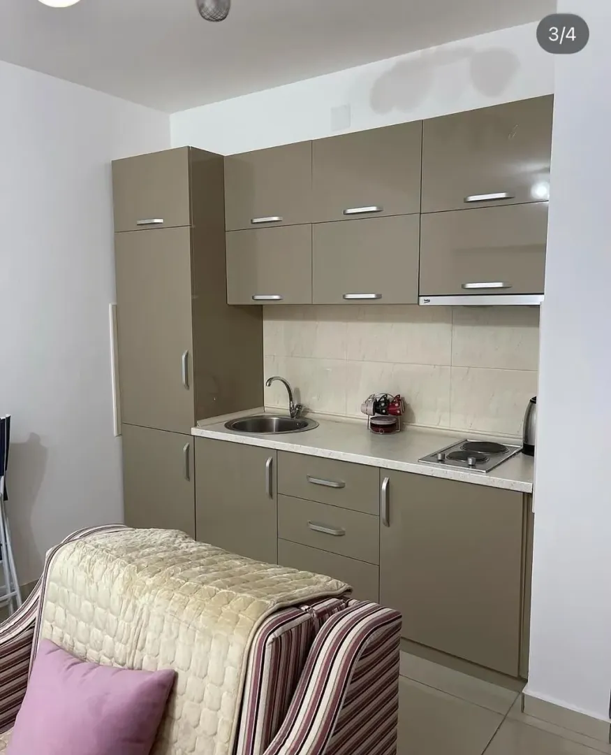 Small kitchen with beige cabinets and a sink.