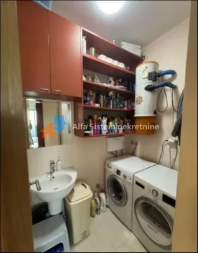 Kupatilo sa umivaonikom, veš mašinom i policama za odlaganje. - image 11