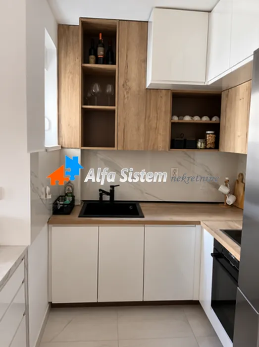 Modern kitchen with white cabinets and wood-grain details.