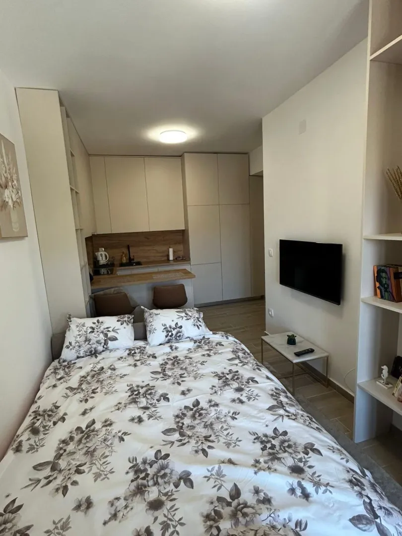 Small bedroom with a double bed, TV, and fitted wardrobes.