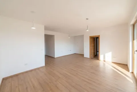 Empty living room with wooden flooring and white walls. - image 3