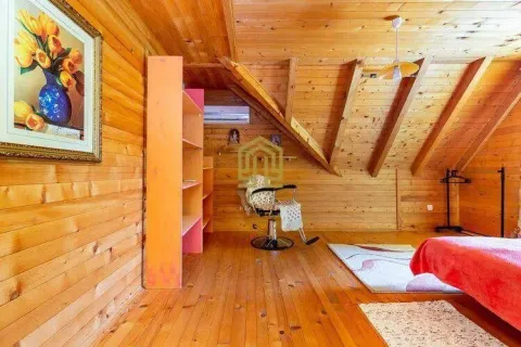 Wood-paneled attic room with a bed and a chair. - image 8