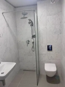 Moderne kupatilo sa tuš kabinom obloženom pločicama sa dezenom mermera. - image 8