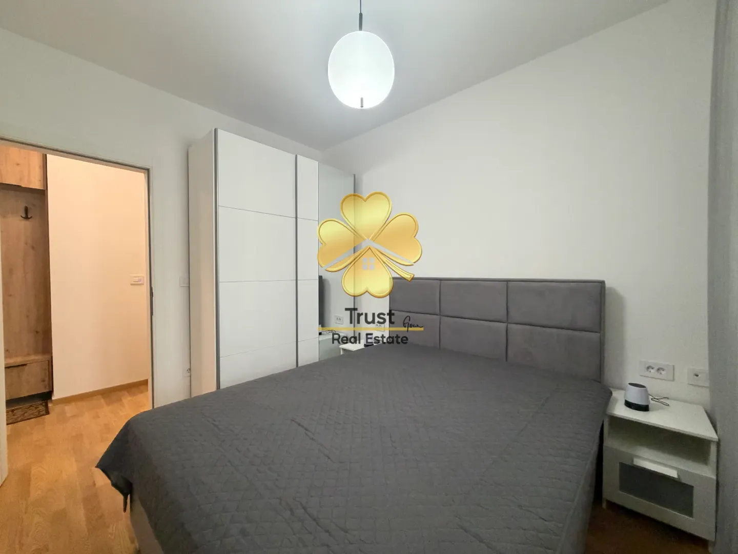 Modern bedroom with a double bed, wardrobe, and a nightstand.