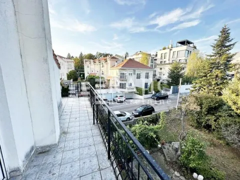View from the tiled terrace towards surrounding buildings and greenery. - image 17