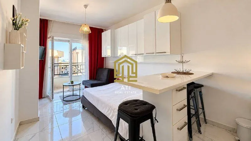 View of the living room with a bed and a breakfast bar.