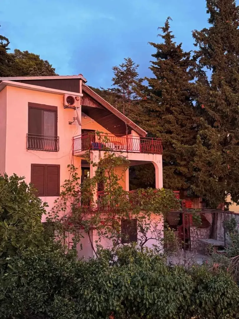 Pogled na spoljašnost kuće sa terasama i zelenilom.