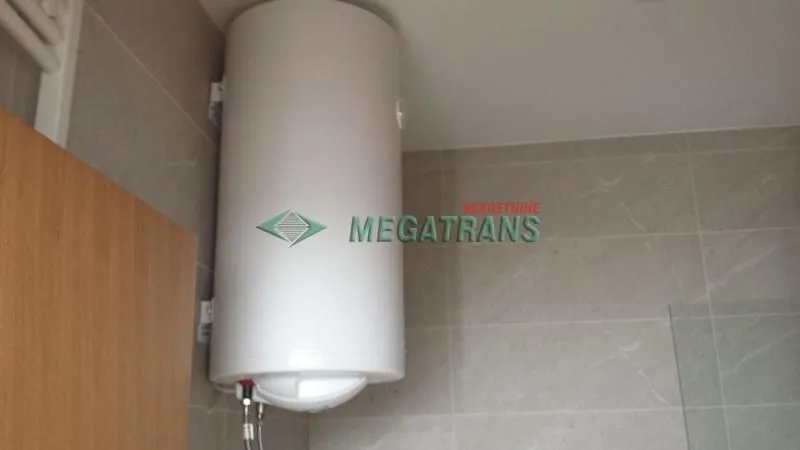 Water heater mounted on a tiled wall in the bathroom.