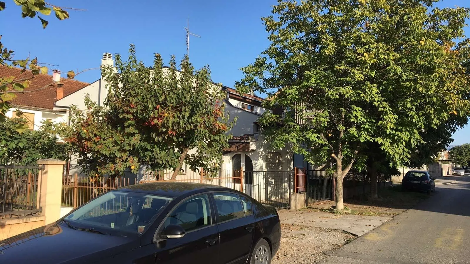 Exterior view of the house with a yard, taken from the street.