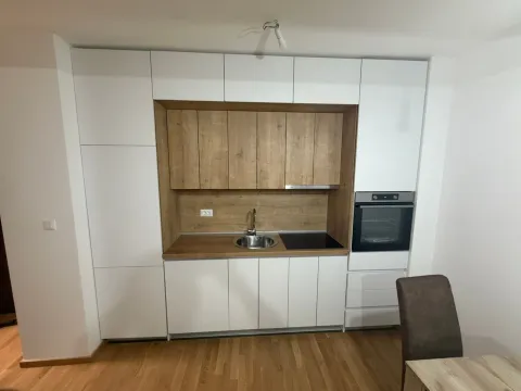 Modern kitchen with white units and wooden details. - image 7