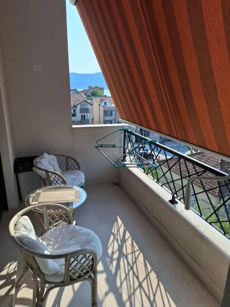 Natkriveni balkon sa garniturom za sjedenje i pogledom na okolinu.