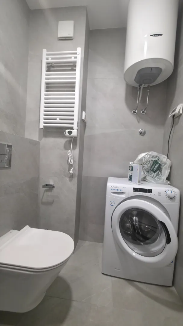 Modernly equipped bathroom with a washing machine and water heater.
