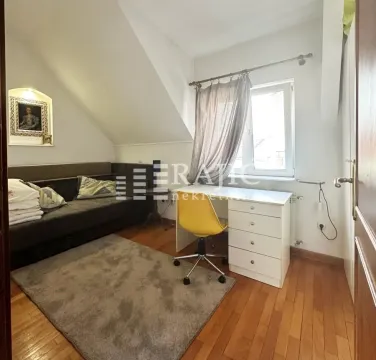 Smaller room with a bed, desk, and rug. - image 8