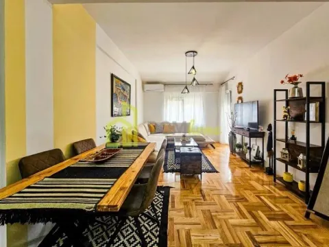 Living room with dining area and parquet flooring. - image 2